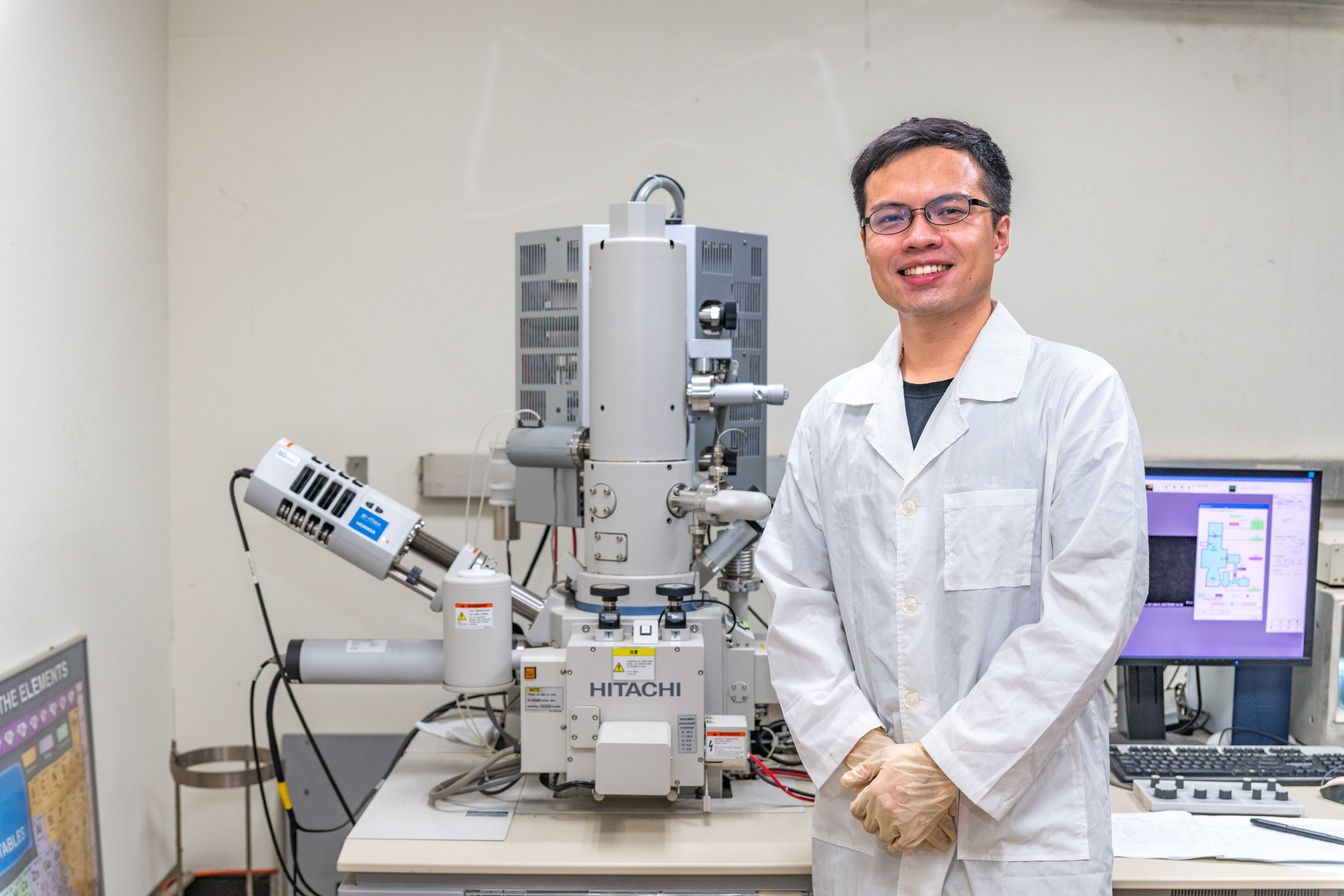 Master's student Neng-Jie Zeng (曾能杰) (left) from NTHU's Institute of Molecular Medicine uses a microscope to observe the immobilization of nematodes controlled by light.