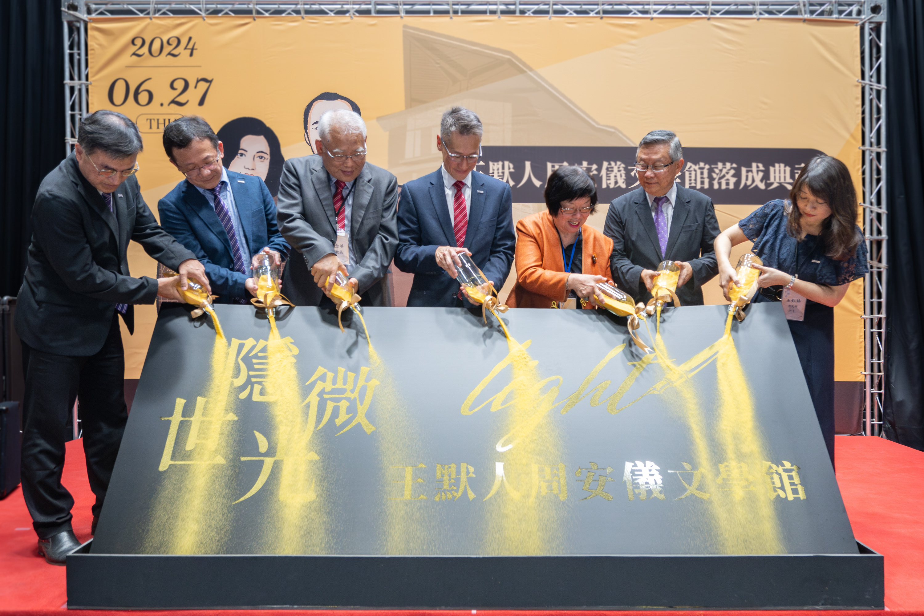 Ms. An-Yi Chou (周安儀), the building's supervisor and donor, declared its completion with a golden brushstroke. Pictured from left to right: Hsiang-Kuang Chang (張祥光), Chief of General Affairs; Cho-Ying Li (李卓穎), Dean of the College of Humanities and Social Sciences; Nien-Hua Tai (戴念華), Vice President; W. John Kao (高為元), President; Ms. An-Yi Chou (周安儀), donor; Hong Hocheng (賀陳弘), former President; and Yu-Ting Wang (王鈺婷), Director of the Institute of Taiwan Literature.