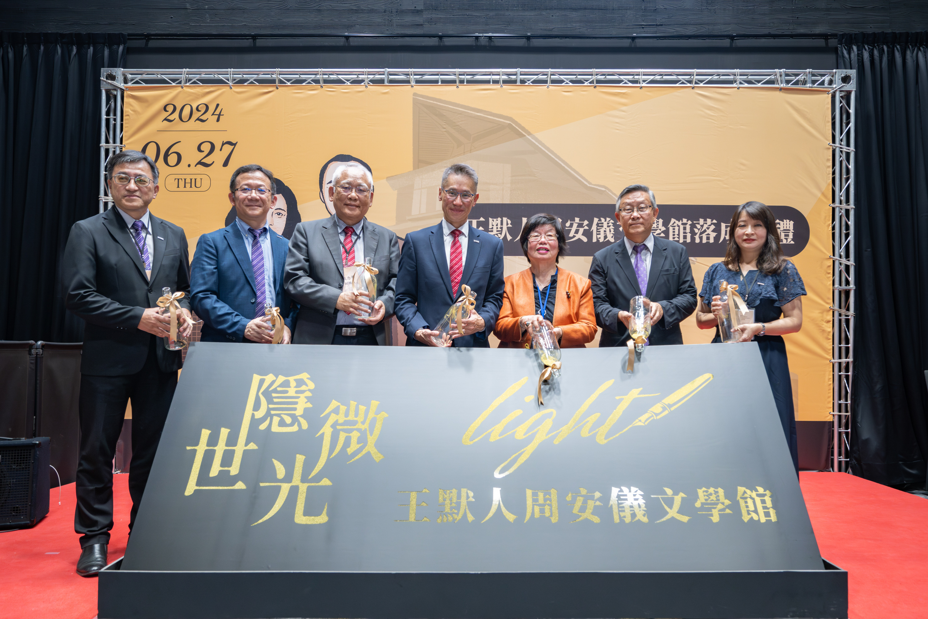 Ms. An-Yi Chou (周安儀), the building's donor, declared its completion with a golden brushstroke. Pictured from left to right: Hsiang-Kuang Chang (張祥光), Chief of General Affairs; Cho-Ying Li (李卓穎), Dean of the College of Humanities and Social Sciences; Nien-Hua Tai (戴念華), Vice President; W. John Kao (高為元), President; Ms. An-Yi Chou (周安儀), donor; Hong Hocheng (賀陳弘), former President; and Yu-Ting Wang (王鈺婷), Director of the Institute of Taiwan Literature.